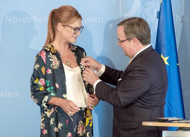 Andrea Berg bekommt den NRW-Verdienstorden von Ministerpräsident Armin Laschet angesteckt.