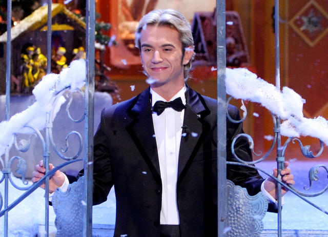 Florian Silbereisen bei seinem ersten „Adventsfest der Volksmusik“ im Jahr 2004. Florian Silbereisen lächelt durch ein schmiedeeisernes Tor auf Kunstschnee