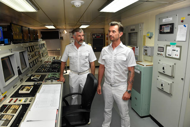 „Das Traumschiff: Antigua“: Martin Grimm (Daniel Morgenroth) und Max Parger (Florian Silbereisen) stehen auf der Brücke des Traumschiffs. Martin schaut Max dabei eindringlich an, der sich von ihm abwendet.