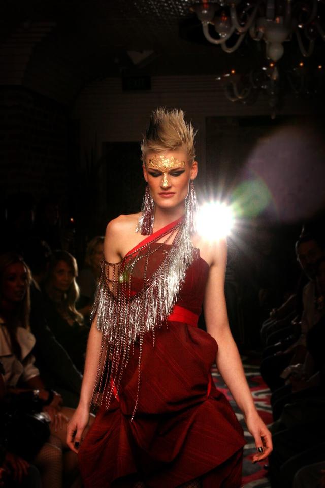 Warum nicht einmal etwas extravaganter? Frau in rotem Kleid auf Catwalk