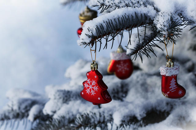 Ein mit Schmuck behangener Weihnachtsbaum, auf dem Schnee liegt