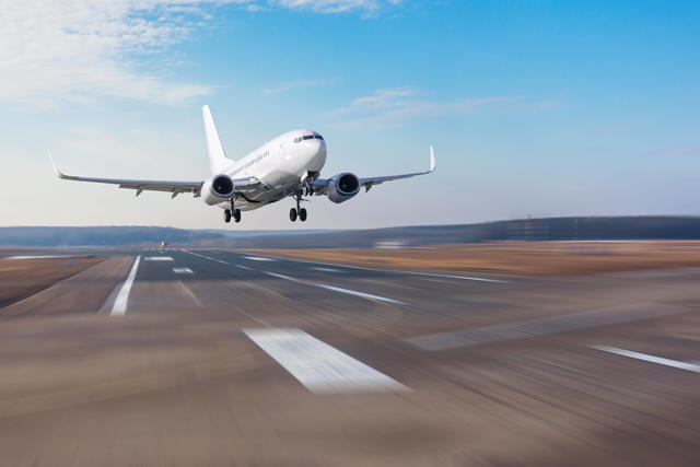 Ein Flugzeug auf einer Startbahn hebt gerade ab.