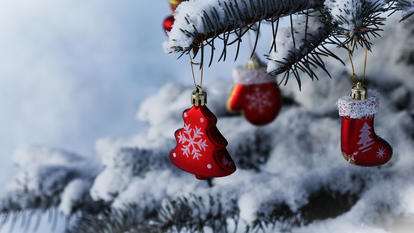 Ein mit Schmuck behangener Weihnachtsbaum, auf dem Schnee liegt