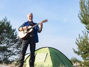 So lieben ihn seine Fans: Camping-Kalle (Christoph M. Ohrt) mit Gitarre und Zelt in „Camping mit Herz“. 