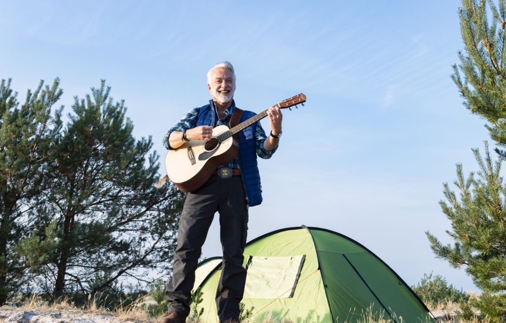 So lieben ihn seine Fans: Camping-Kalle (Christoph M. Ohrt) mit Gitarre und Zelt in “Camping mit Herz”. 