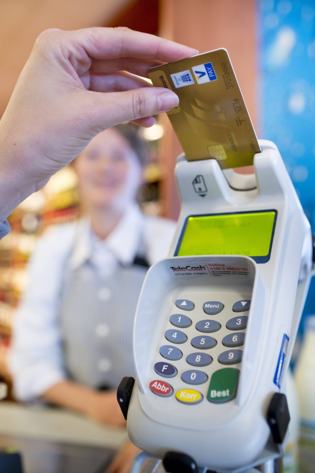 Eine Frau steckt ihre Bankkarte in ein Kartenlese-Gerät, um zu bezahlen.