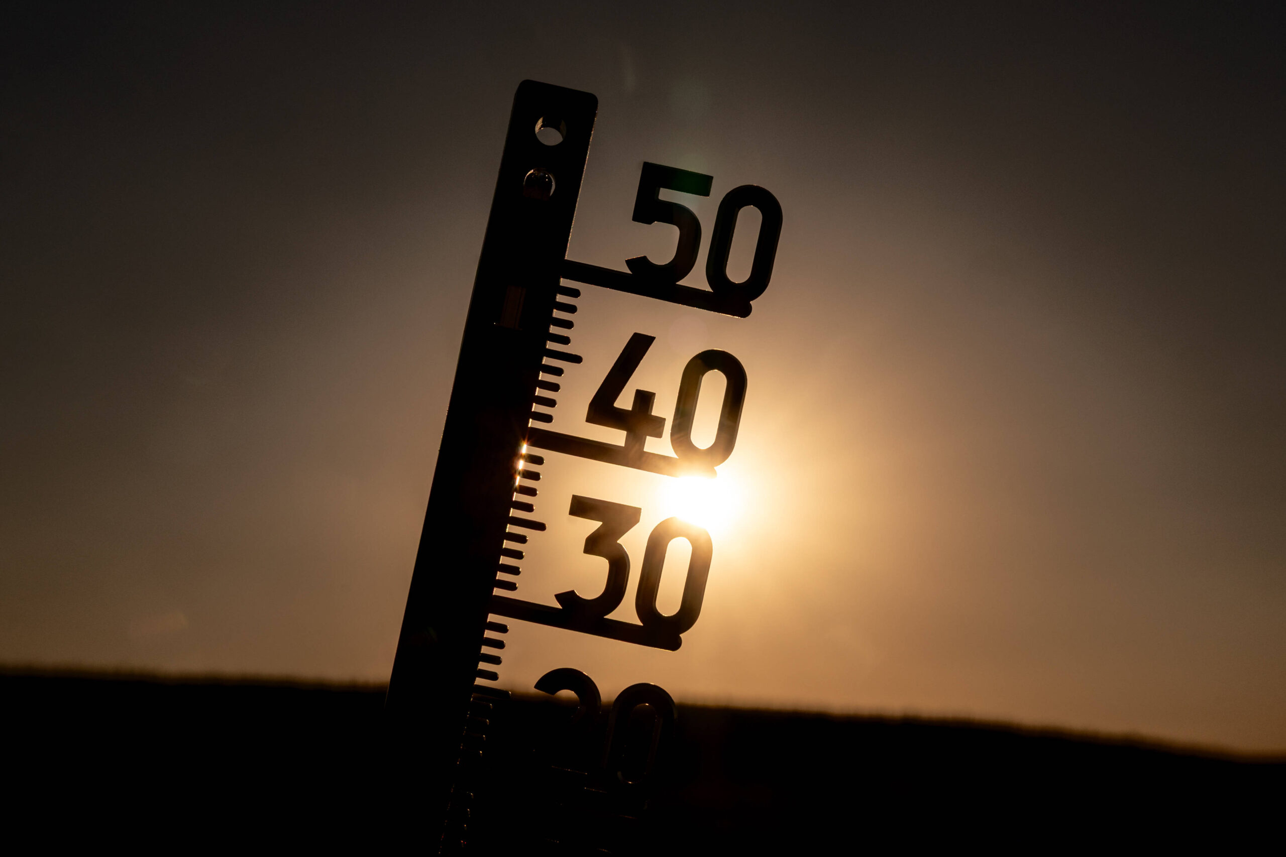 Außenthermometer im Gegenlicht der Sonne als Symbol für eine Hitzewelle