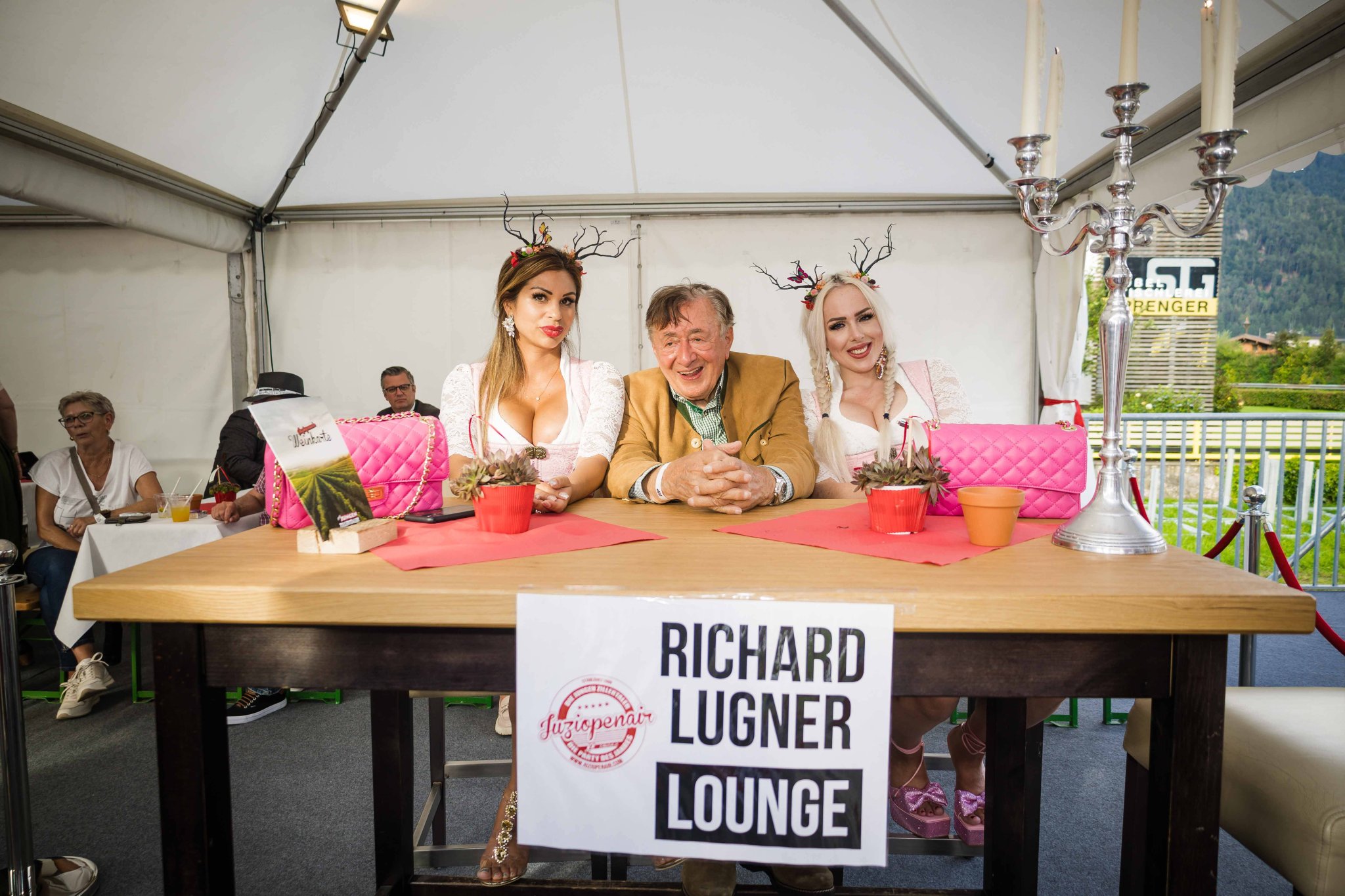 Richard Lugner steht mit Nina „Bambi“ Bruckner und Lydia Kelovitz beim Juzi Open Air im Zillertal