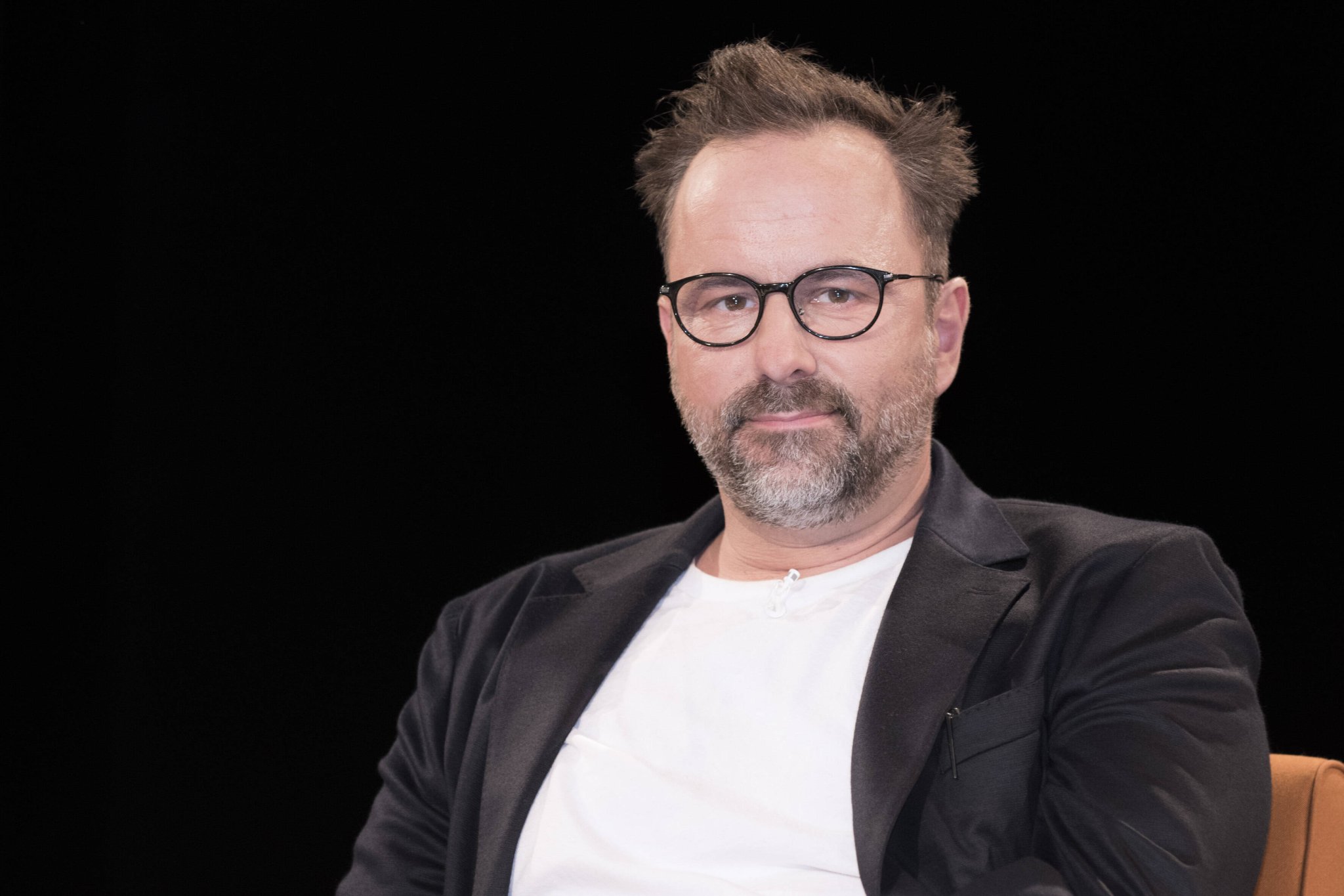 Comedian Kurt Krömer mit Brille vor dunklem Hintergrund