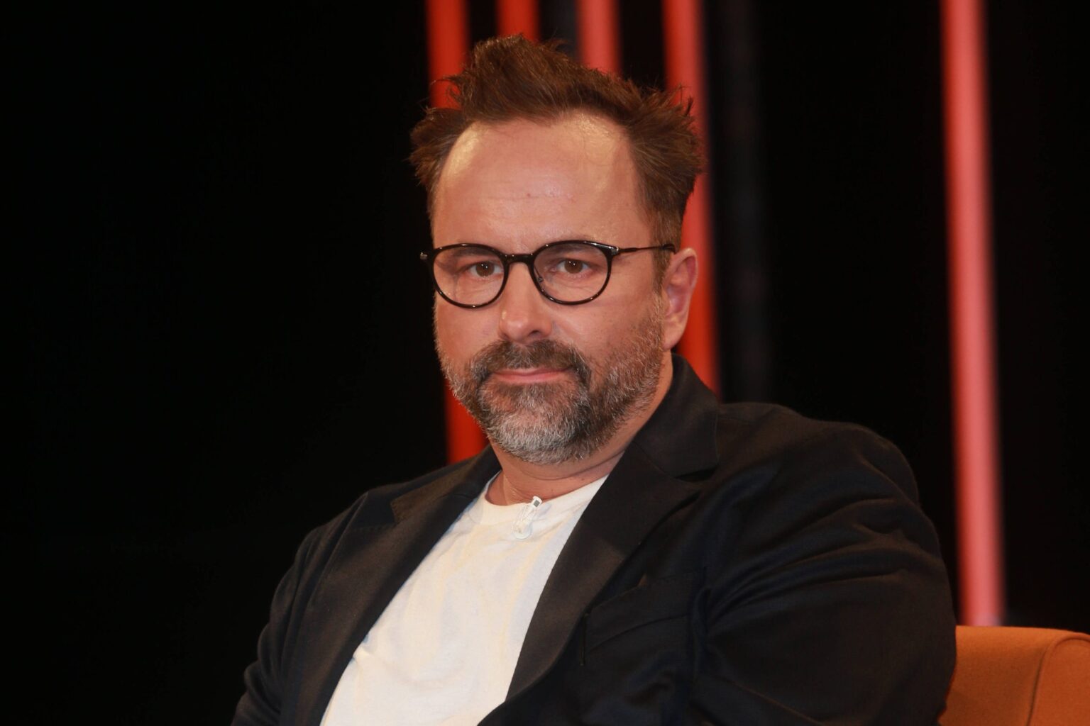 Kurt Krömer mit Brille und dunklem Sakko in einer Talkshow