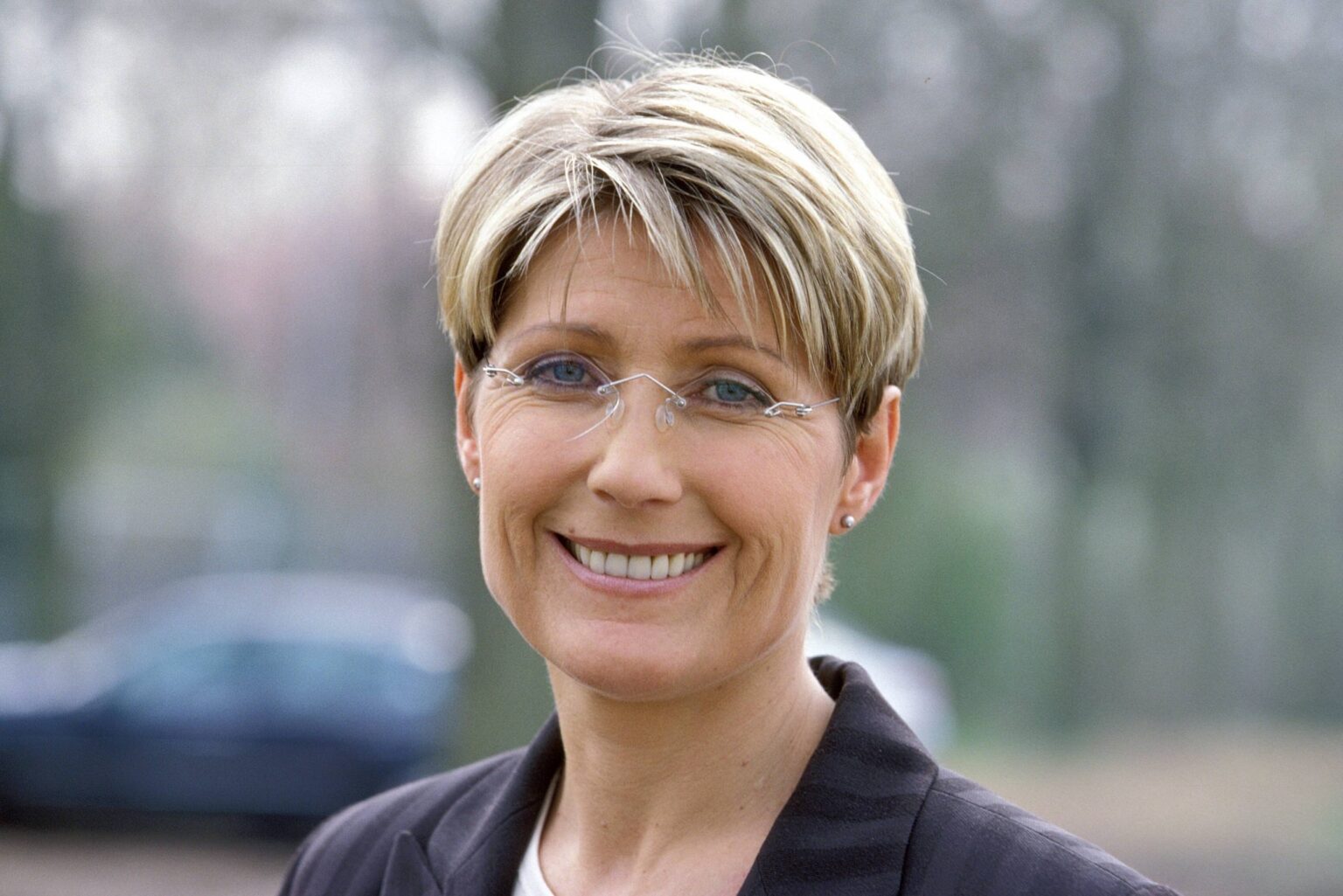 Porträt der Fernsehmoderatorin Jacqueline Stuhler mit Brille und kurzen blonden Haaren