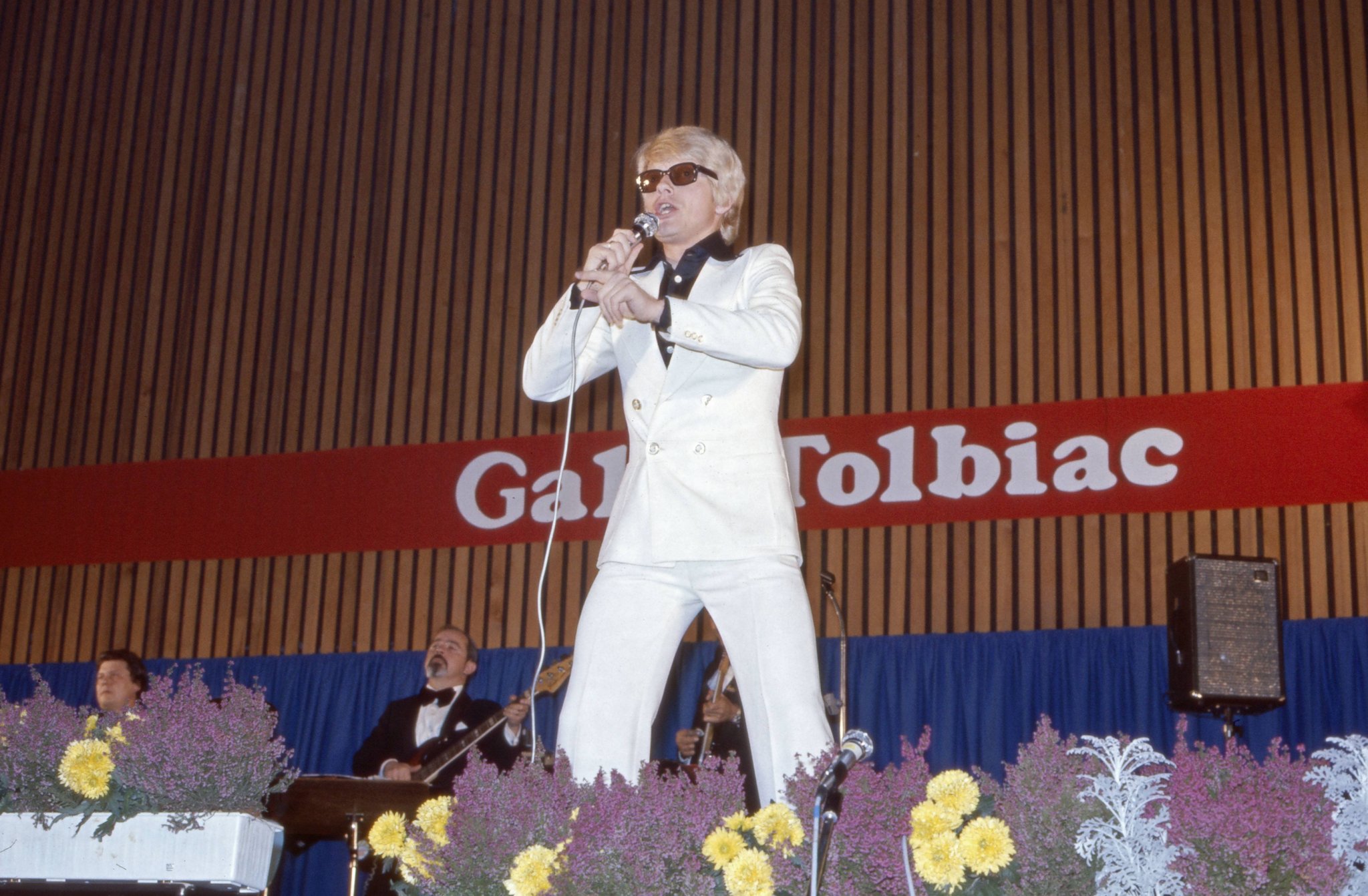 Heino im weißen Anzug mit dunkler Brille singt bei der Gala Tolbiac 1975 auf der Bühne