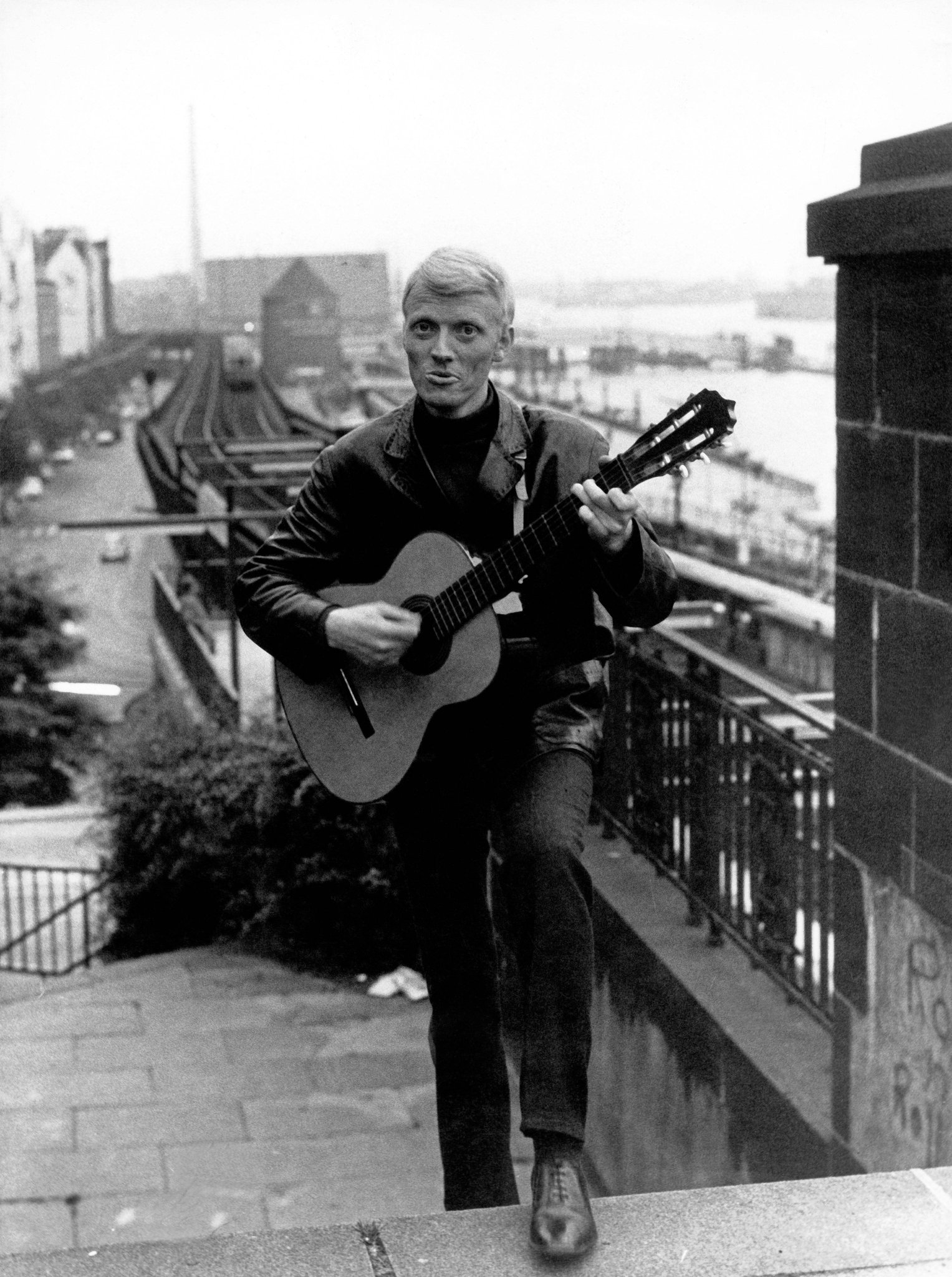 Der junge Heino ohne Sonnenbrille mit Gitarre an den Landungsbrücken in Hamburg, Schwarz-Weiß-Foto aus den 1960er-Jahren
