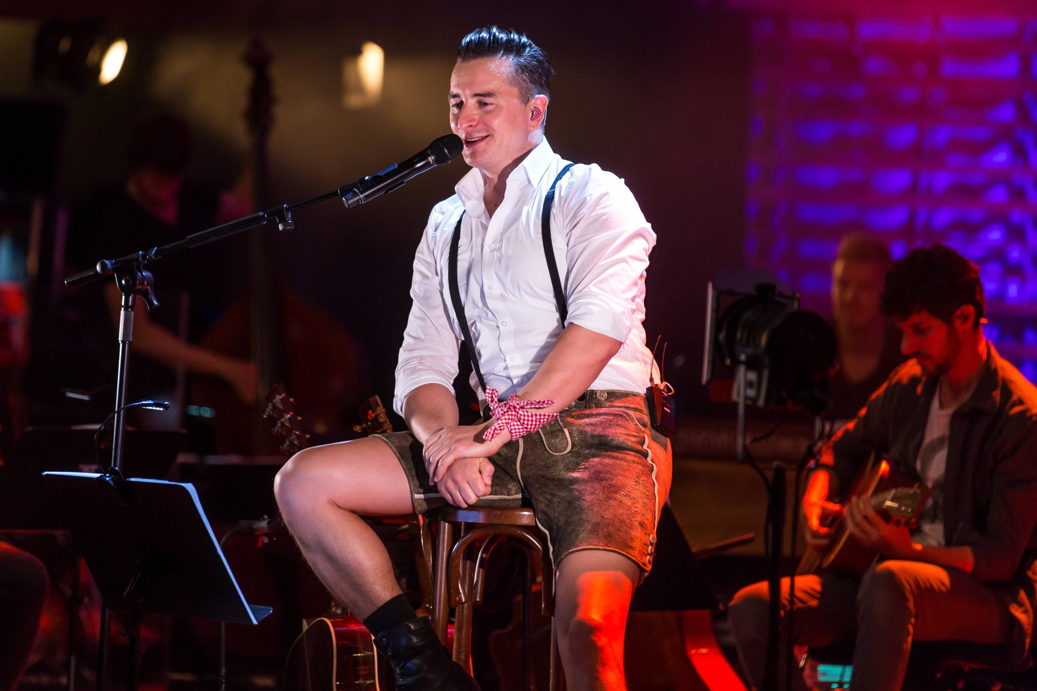 Andreas Gabalier sitzt mit Gitarre und Lederhose bei seiner MTV-Unplugged-Tour 2017 im KKL Luzern auf der Bühne