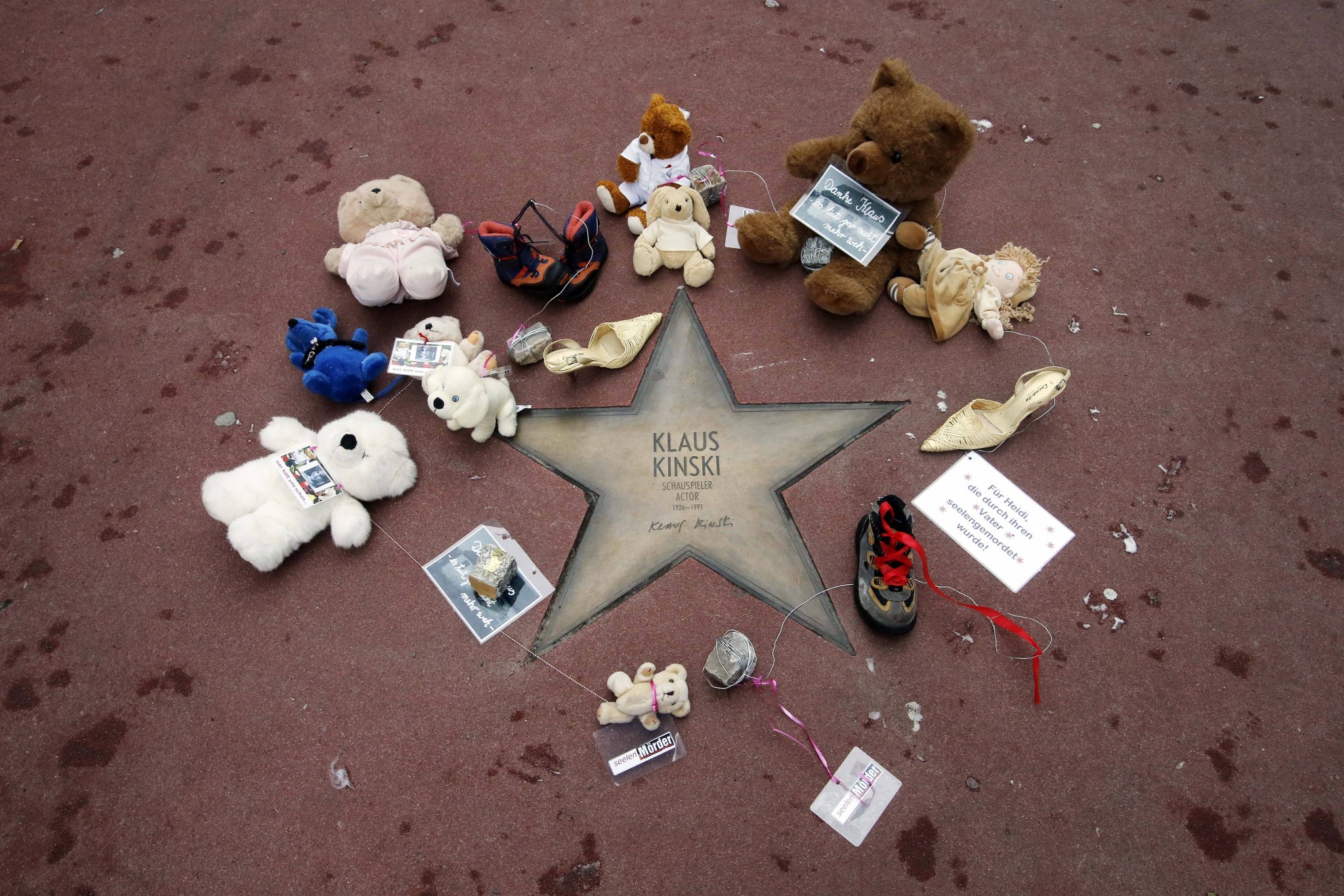 Teddybären und Kinderschuhe am Stern von Klaus Kinski auf dem Boulevard der Stars in Berlin