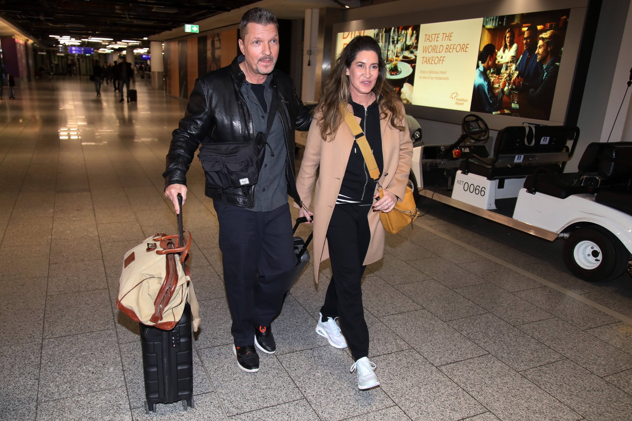 Hardy Krüger jr. und Ehefrau Alice mit Reisegepäck am Frankfurter Flughafen