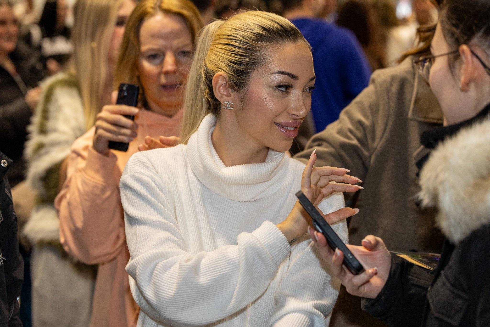 Reality-Star Ariel im weißen Pullover zwischen Fans am Flughafen Frankfurt