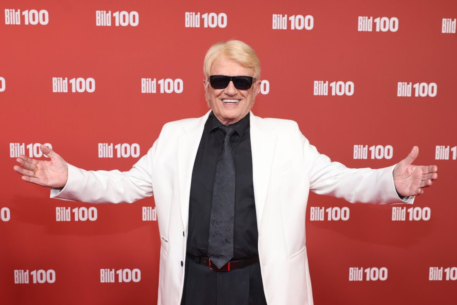 Heino mit dunkler Sonnenbrille und weißem Sakko auf dem roten Teppich bei BILD100 in Berlin