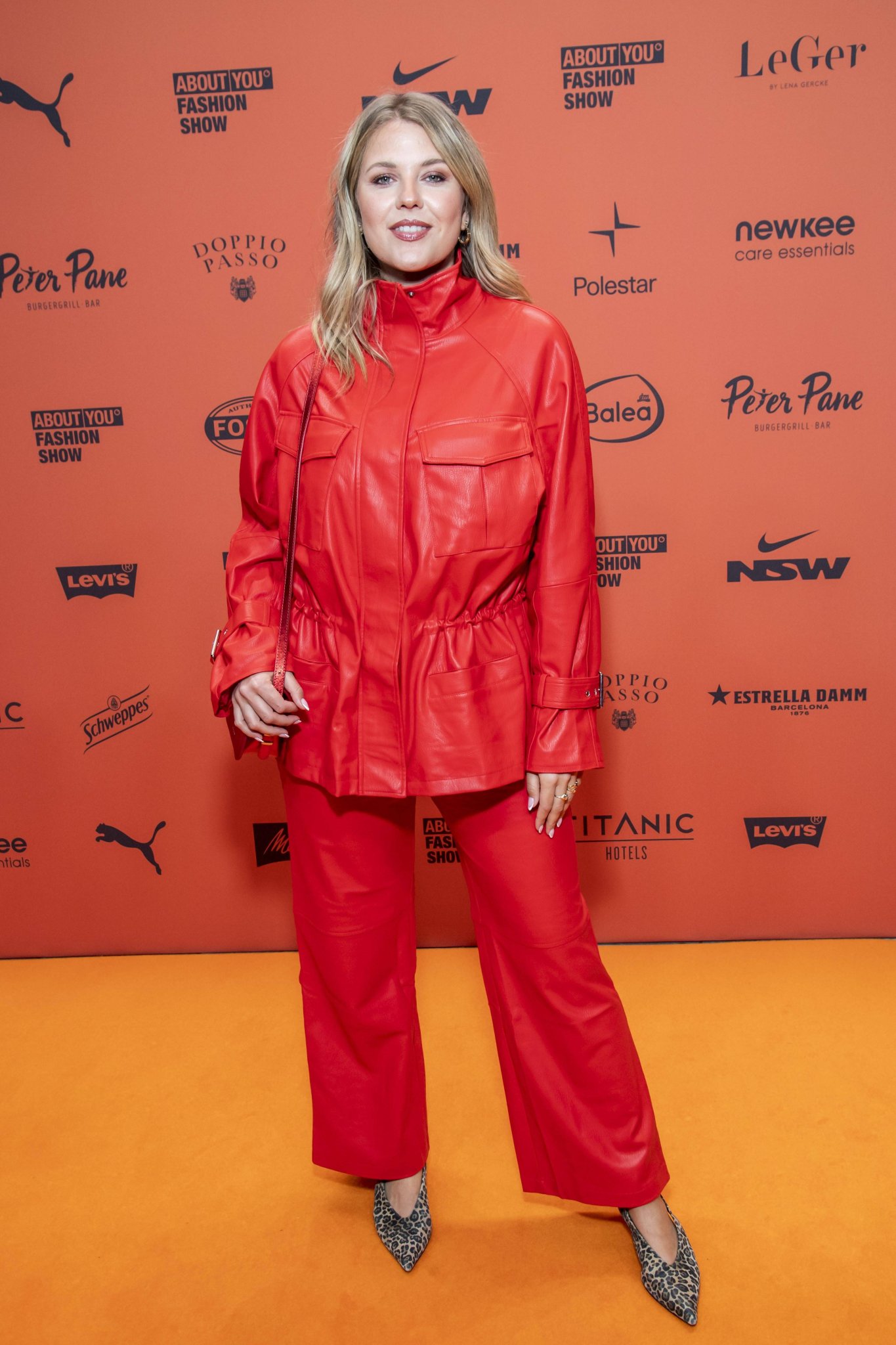 Josefin Bressel im roten Outfit auf dem orangefarbenen Teppich der ABOUT YOU Opera in Berlin